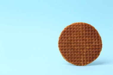 Açık mavi arka planda leziz yuvarlak bir waffle. Metin için boşluk