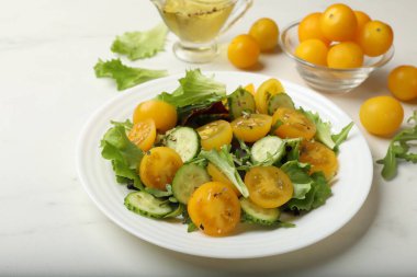 Beyaz masada sarı domatesli taze salata, yakın plan.