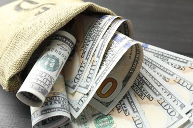 Masada dolar banknotları olan para çantası, yakın plan.