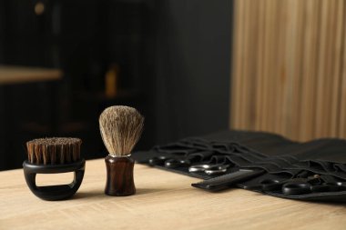 Berber dükkanında, açık ahşap masanın üzerinde birçok farklı berber aleti var.