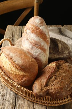 Tahta masadaki sepetin içinde farklı somunlar, yakın çekim.