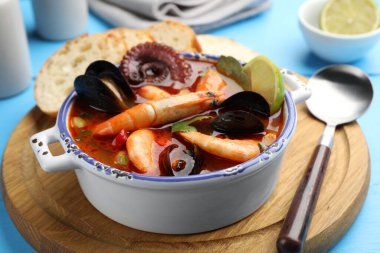 Lezzetli deniz ürünleri çorbası mavi masada, yakın plan.