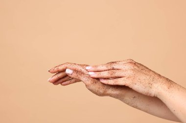 Bej arka planda ellerini ovuşturan kadın, yakın plan.