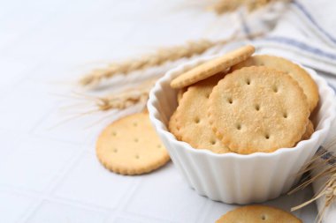 Beyaz fayanslı masa üzerinde buğday dikenli lezzetli krakerler, yakın plan. Metin için boşluk