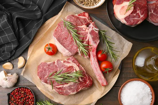 Çiğ et parçaları, ürünler ve baharatlar ahşap masa, düz yatıyordu.