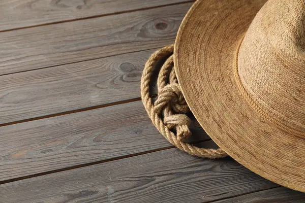 Ahşap arka planda pamuk ip ve hasır şapka, yakın plan. Metin için boşluk