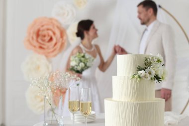 Mutlu evli çift içeride, düğün pastasına ve masadaki şampanya bardaklarına odaklan.