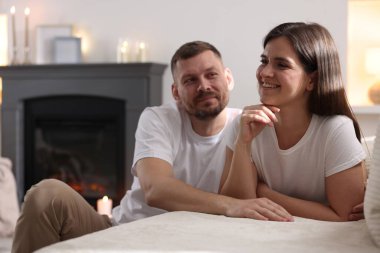 Mutlu çift, şık şömineli bir odada birlikte vakit geçiriyor.