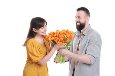 Adam beyaz arka planda sevgili karısına güzel laleler sunuyor.