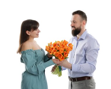 Adam beyaz arka planda sevgili karısına güzel laleler sunuyor.