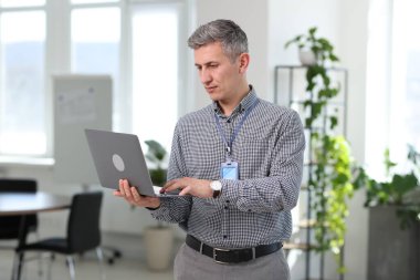 Ofiste dizüstü bilgisayarla çalışan profesyonel bir mühendis.