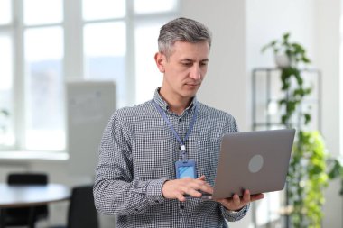 Ofiste dizüstü bilgisayarla çalışan profesyonel bir mühendis.