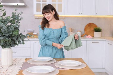 Akşam yemeği için masa hazırlayan kadın.