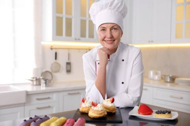 Mutfaktaki masada tatlıları olan profesyonel pasta şefi.