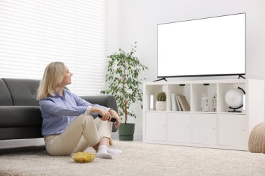 Evde çipli bir kadın televizyon izliyor.