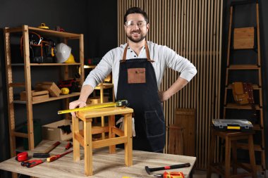 Atölyede tahta taburesi ve aletleri olan profesyonel bir tamirci.