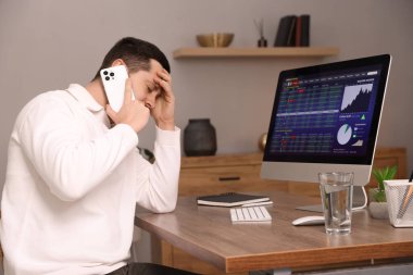 Borsa. İçerideki masada akıllı telefondan konuşan adam.