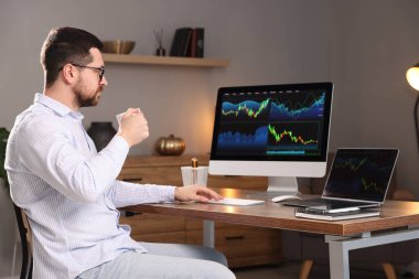 Borsa. İçkili bir adam, kapalı mekândaki finans piyasasını inceliyor.
