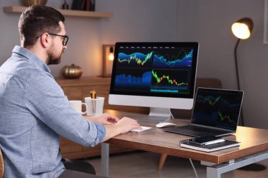 Borsa. Kapalı alandaki bilgisayarda finansal piyasayı analiz eden adam.