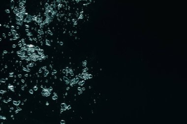 Siyah arka planda bir sürü su kabarcığı var, yakın plan. Metin için boşluk
