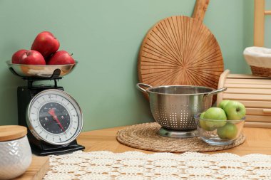 Kitchen scale, products and cooking utensils on wooden table