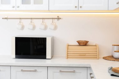 Mutfak tezgahında kapalı mikrodalga fırın.