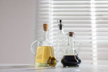 Mutfaktaki masada salata sosu ve zeytin.