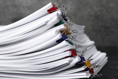 Masanın üzerinde kağıt kağıtları olan ataçlar, yakın plan