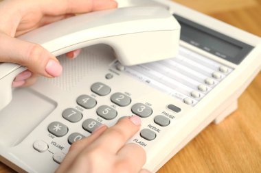 Ahşap masada telefonla arayan kadın, yakın plan.