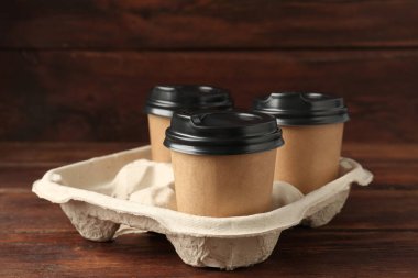 Kağıt kahve bardakları ahşap masanın üzerinde, yakın plan.