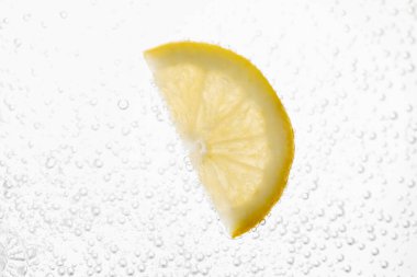 Soda water with lemon slice as background, closeup