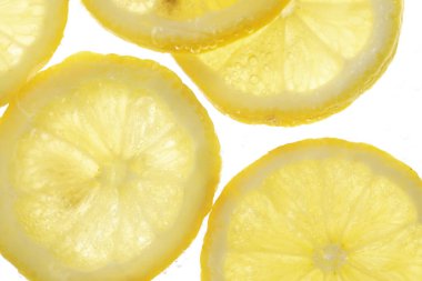 Arka planda limon dilimleri olan soda, yakın plan.