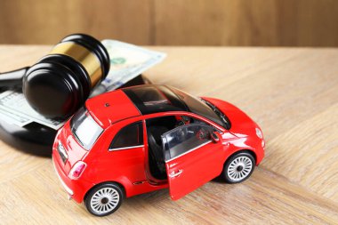 Motorlu taşıt kazası yasası. Gavel, para ve araba modeli ahşap arka planda, yakın plan.