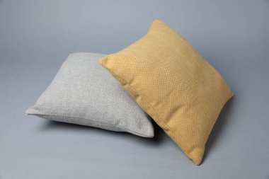 Gri arkaplanda iki yumuşak dekoratif yastık