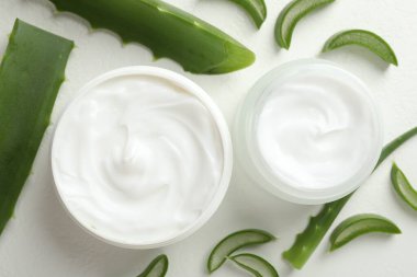 Aloe vera özütüyle nemlendirici krem ve beyaz desenli arka planda yapraklar.