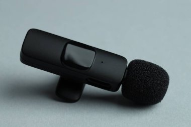 Gri arka planda Lavalier mikrofonu, yakın plan. Ses ekipmanları