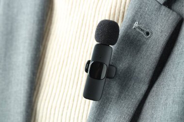 Gömleğinde lavalier mikrofon olan bir kadın, yakın plan.