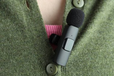 Gömleğinde lavalier mikrofon olan bir kadın, yakın plan.