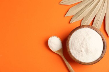 Kasede kolajen tozu, turuncu arka planda kaşık ve kuru palmiye yaprağı. Metin için boşluk