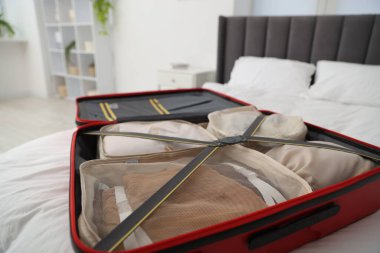 Küpleri bavula koyup yatağın içine koyuyor, yakın plan çekiyoruz.