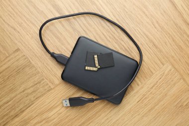 USB kablo ve SD hafıza kartlı harici sabit disk açık tahta masa, üst görünüm