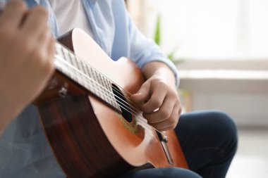 Evde gitar çalan adam, eline odaklan.