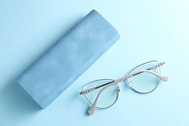 Açık mavi arka planda şık gözlüklü çanta, düz uzanma
