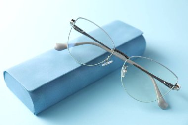 Açık mavi arka planda şık gözlüklü çanta, yakın plan