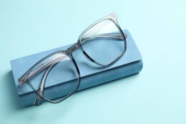 Açık mavi arka planda şık gözlüklü çanta