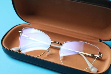 Açık mavi arka planda şık gözlüklü çanta, yakın plan