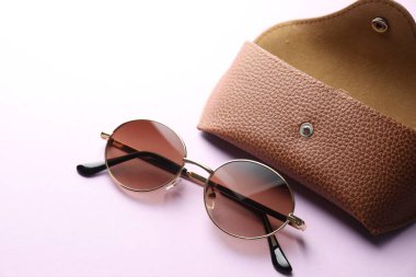 Mor arka planda şık gözlüklü çanta, yakın plan