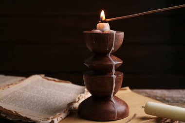 Mumları şamdanla yakıyorum. Masada, yakın plan.