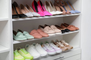 Ayakkabı deposu. Bir sürü farklı ayakkabı çifti olan raf ünitesi kapalı, yakın plan.