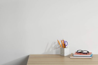 Ahşap ofis masasında farklı kırtasiye ve gözlük beyaz arkaplan, metin için yer